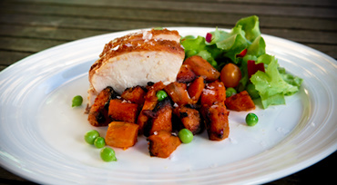 fersken glaseret kylling med sweet-potato tern, håndpillede ærter og salat